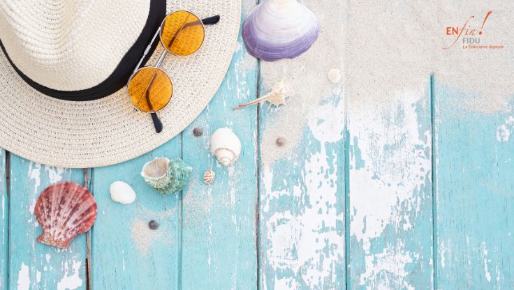 Chapeau, lunettes de soleil et coquillages posés sur une table en bois, symbolisant la fin des vacances et la préparation de la rentrée d'une PME avec une meilleure organisation et un pilotage financier.