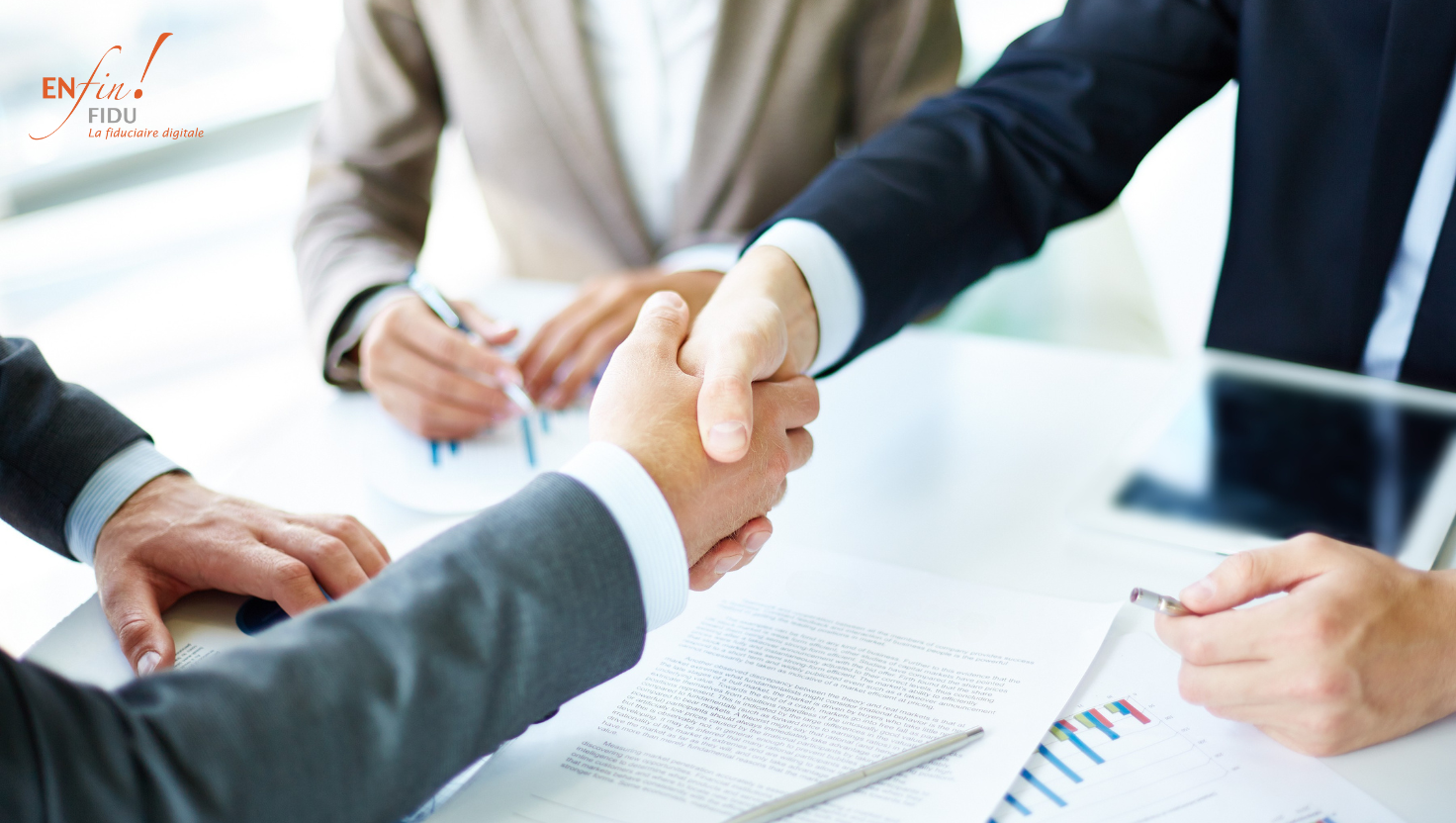Deux hommes en tenue professionnelle se serrent la main au-dessus de papiers signés, une troisième personne assise au bureau observe l’échange, symbolisant un accord sécurisé et confiance dans la transmission d’entreprise.