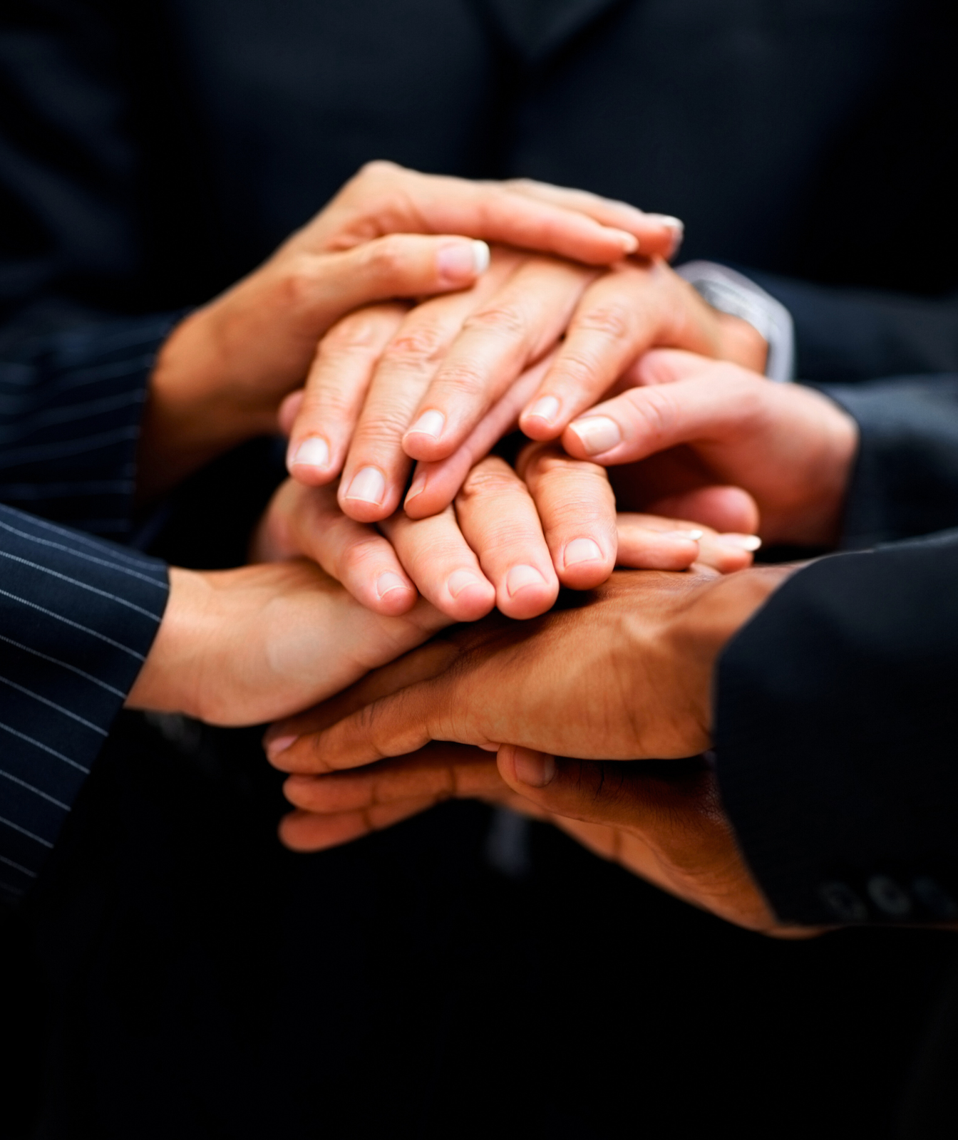 Groupe de professionnels debout en cercle, se donnant la main au centre, symbolisant une gouvernance d’entreprise unie, collaborative et responsable